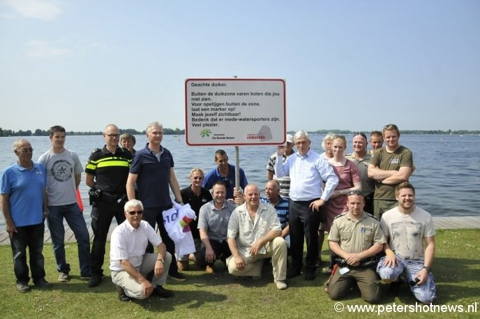 In het bijzijn van betrokken instanties hebben wethouder Anco Goldhoorn (rechts naast het bord) en Raymond de Rijk van Ondernemersvereniging Vinkeveen (links naast het bord met vlag in de hand) het duikersbord onthuld. Foto door Rob Isaacs