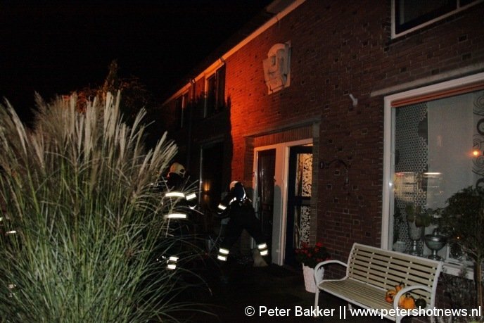 De brandweer ramt de deur in