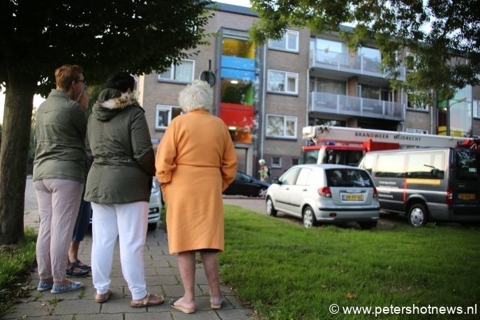 Bewoners staan buiten te wachten tot ze weer naar huis mogen. Even later werd de naastgelegen school open gesteld.